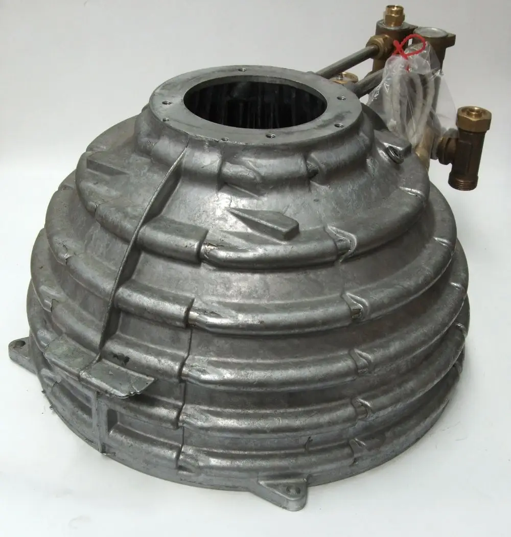Stück aus Metall mit gewölbter, gestufter Oberfläche und Anschlussventilen, möglicherweise Teil eines Wärmetauschers von Daikin.
